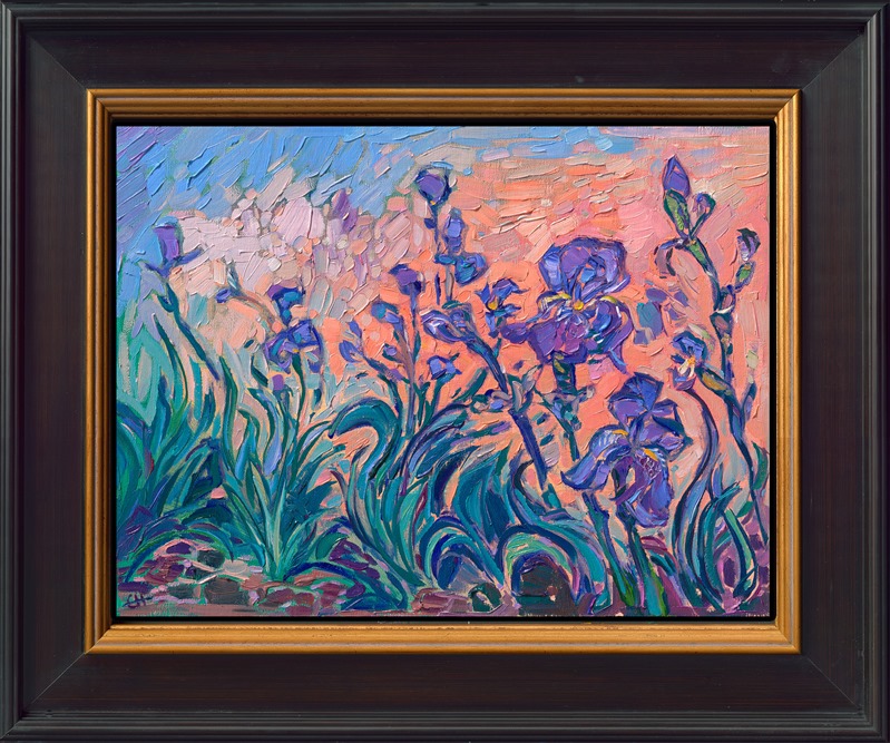 A cluster of purple irises bloom in the red earth of Sedona, Arizona. This painting captures the striking color contrasts of flowers in the desert. Short, expressive brushstrokes bring texture and movement to the piece.